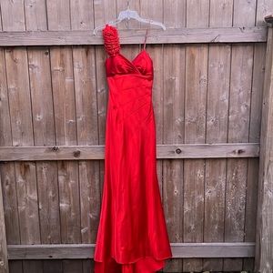 Red evening gown with asymmetrical sleeve detail and small train